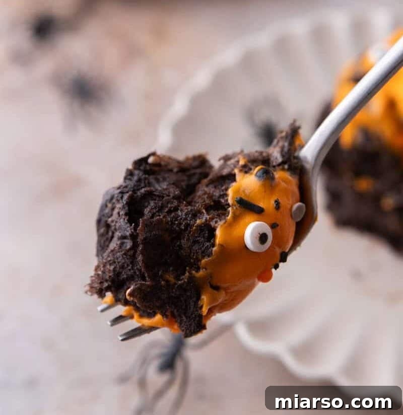 Black Cocoa Cinnamon Rolls with a bite on a spoon