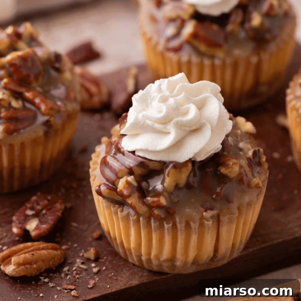 Delightful Mini Pecan Pie Cheesecakes, elegantly topped with fluffy whipped cream, ready to impress at any gathering.