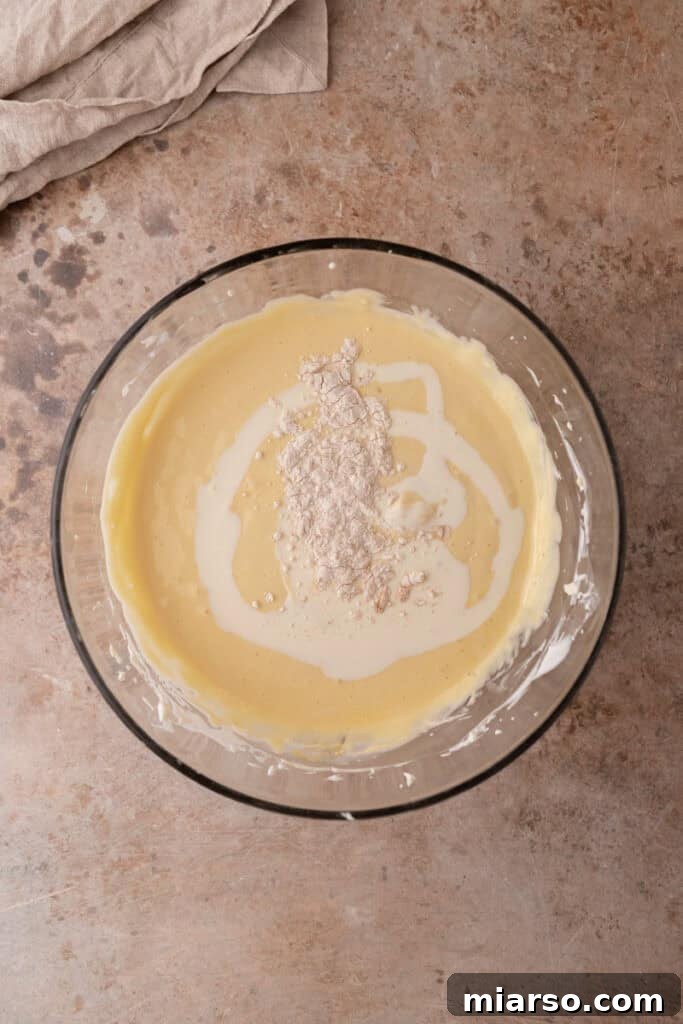 Heavy cream and flour are carefully folded into the cheesecake batter, completing the creamy filling.