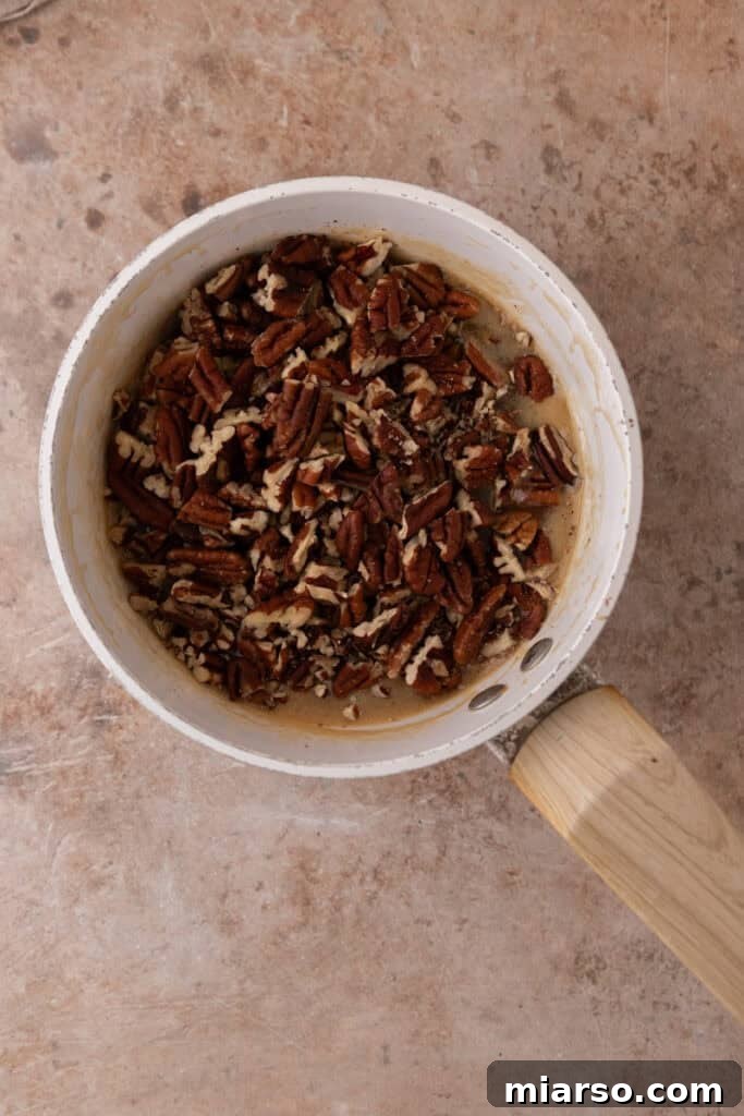 Toasted and chopped pecans are folded into the warm caramel mixture, adding texture and nutty flavor.