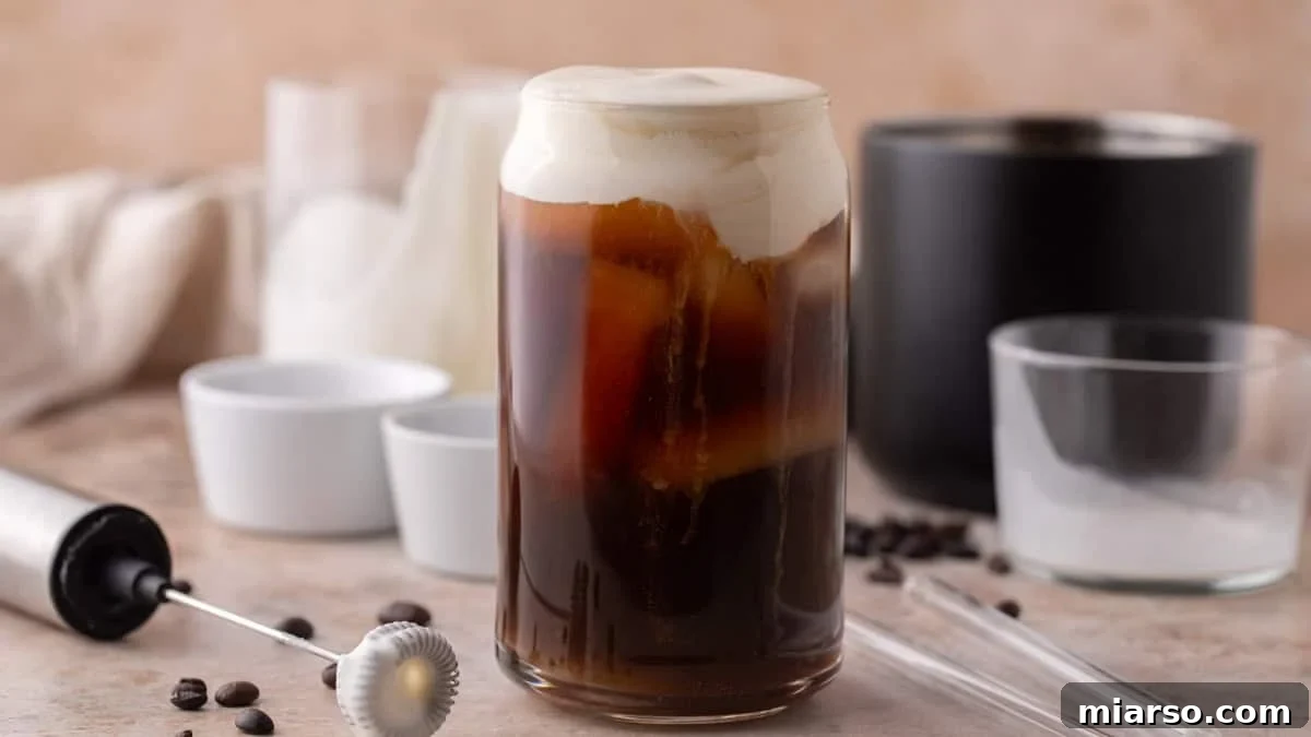 Starbucks Inspired High Protein Cold Foam 2 A refreshing glass of iced cold brew, beautifully topped with a thick, homemade protein cold foam, creating a distinct creamy layer over the dark coffee.