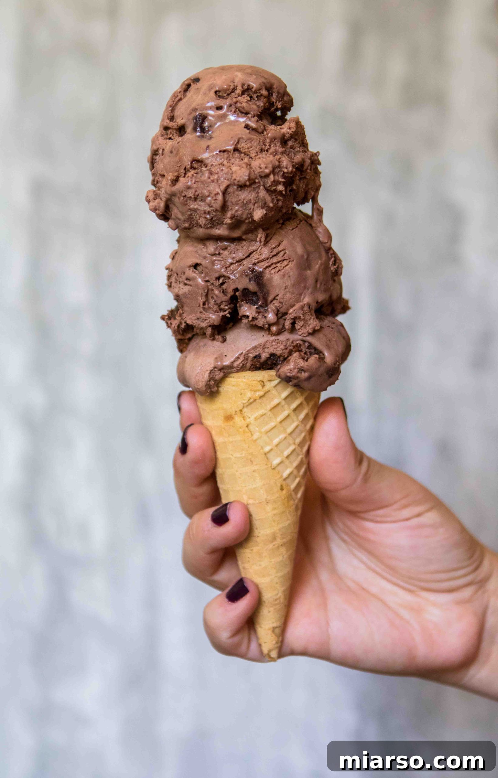 Scoops of homemade chocolate no-churn ice cream with brownie pieces.