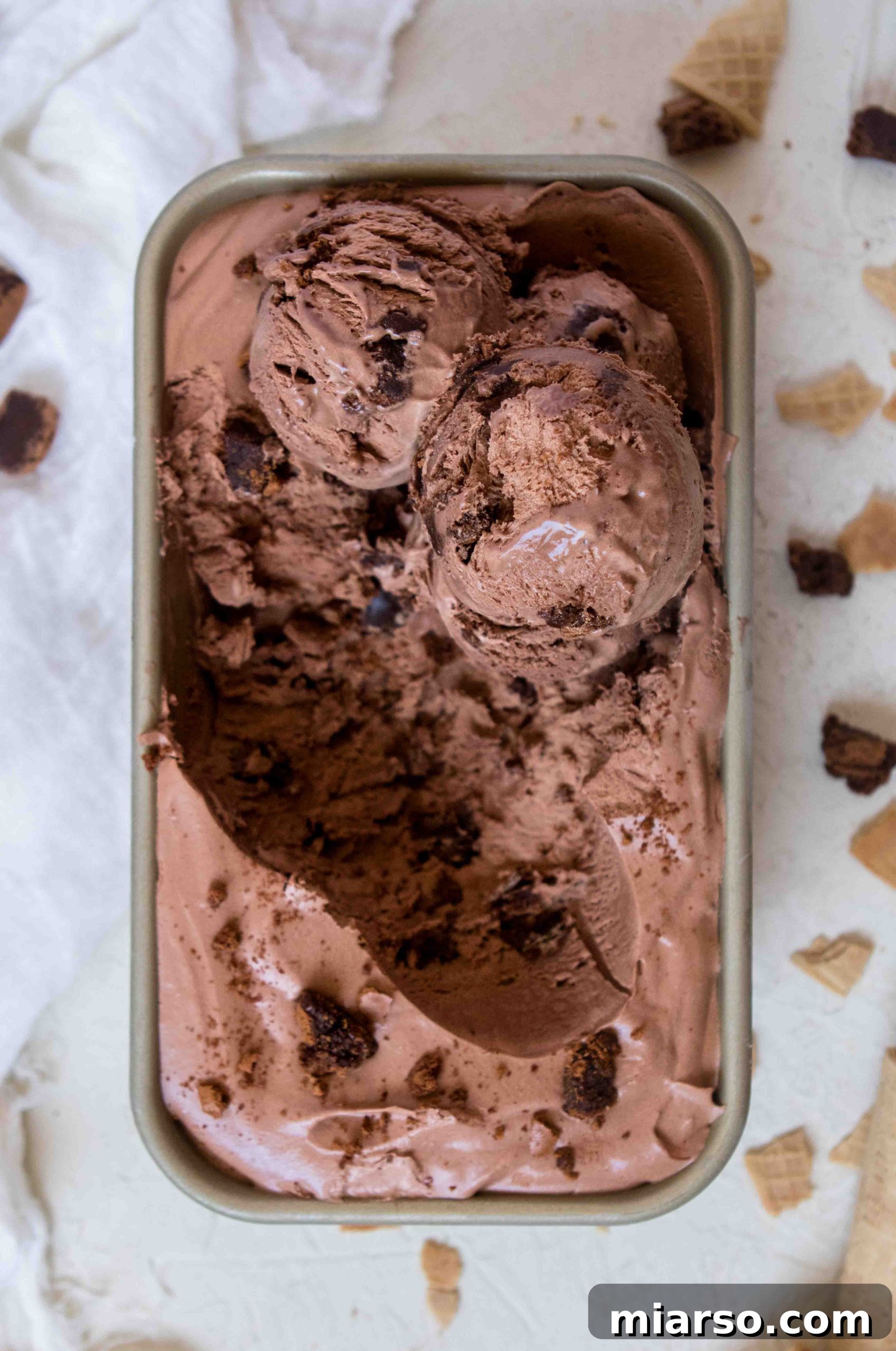 Close-up of creamy no-churn chocolate ice cream with visible brownie chunks.