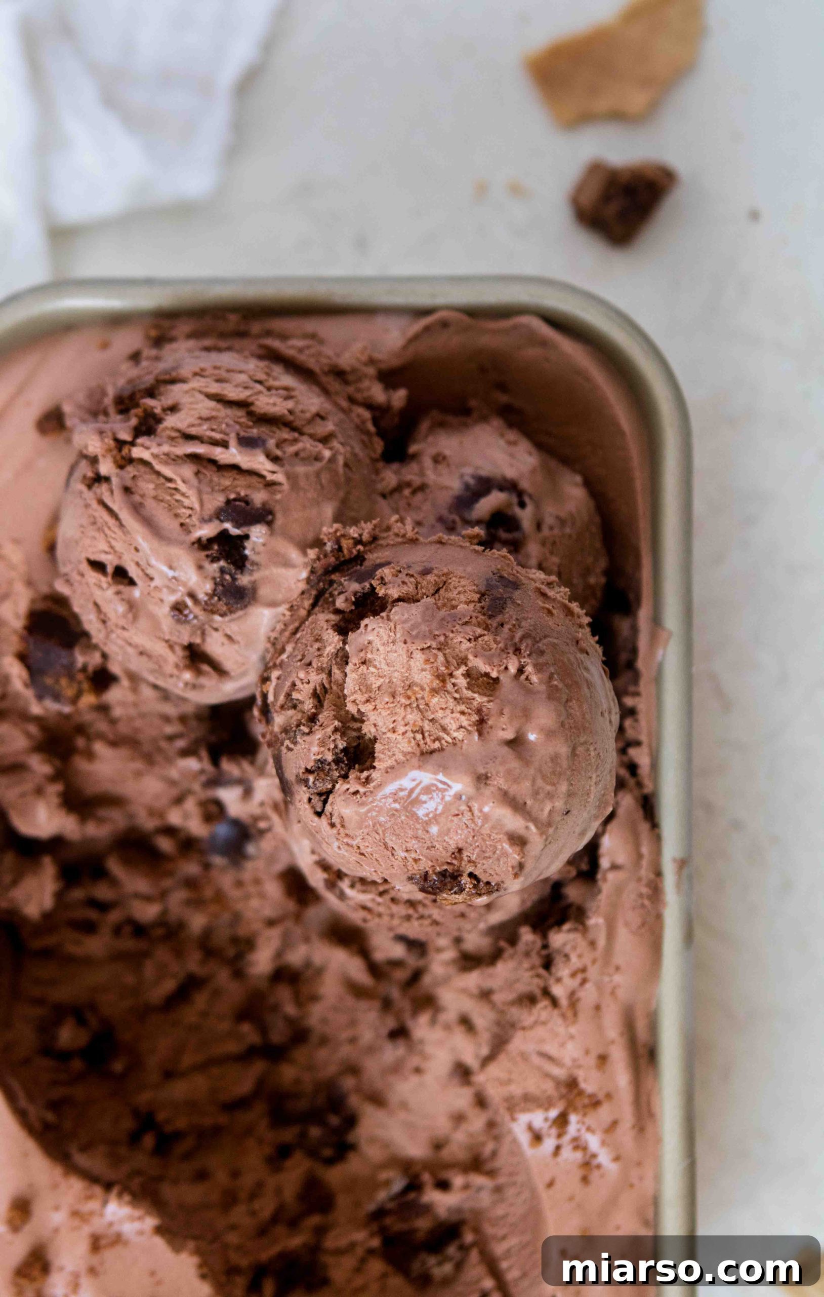 Scoops of no churn chocolate ice cream with brownie pieces in a bowl.