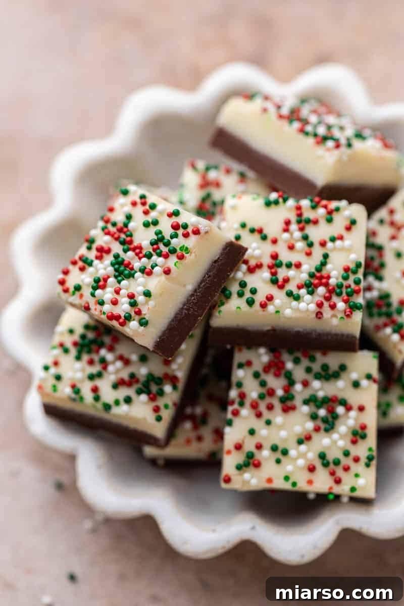 A close-up view of classic Christmas chocolate fudge squares adorned with festive sprinkles.