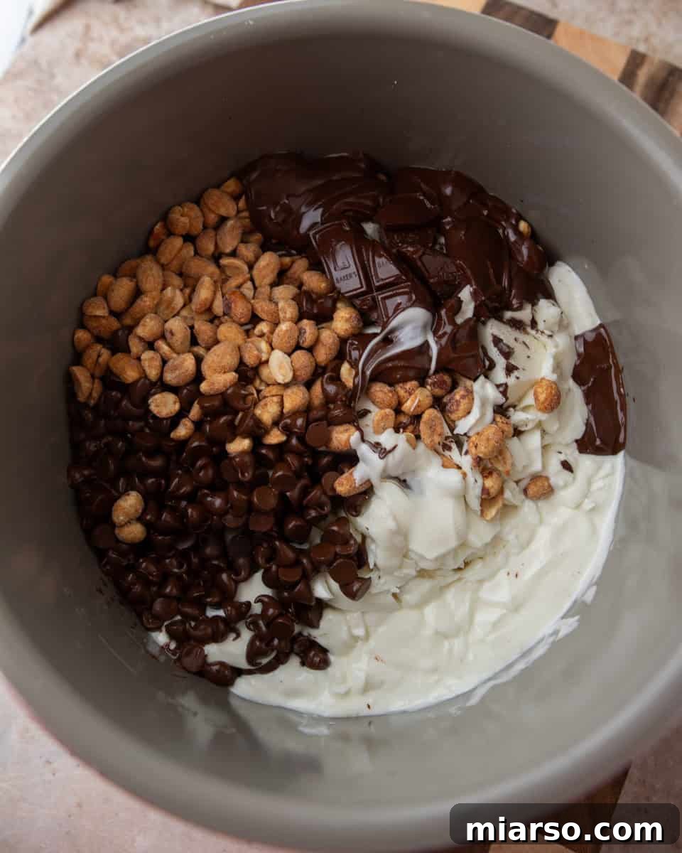 Effortless Slow Cooker Chocolate Peanut Clusters 4 Raw ingredients, including various chocolates and peanuts, carefully layered inside a slow cooker, ready for melting.