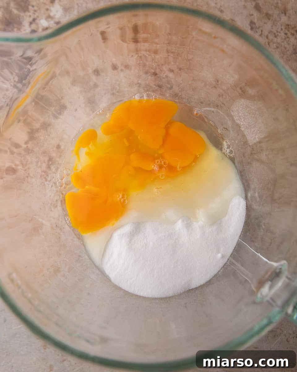 Ina Garten's Viral Brownie Pudding Sensation 4 Fresh eggs and granulated sugar in a clear mixing bowl, ready to be whipped.
