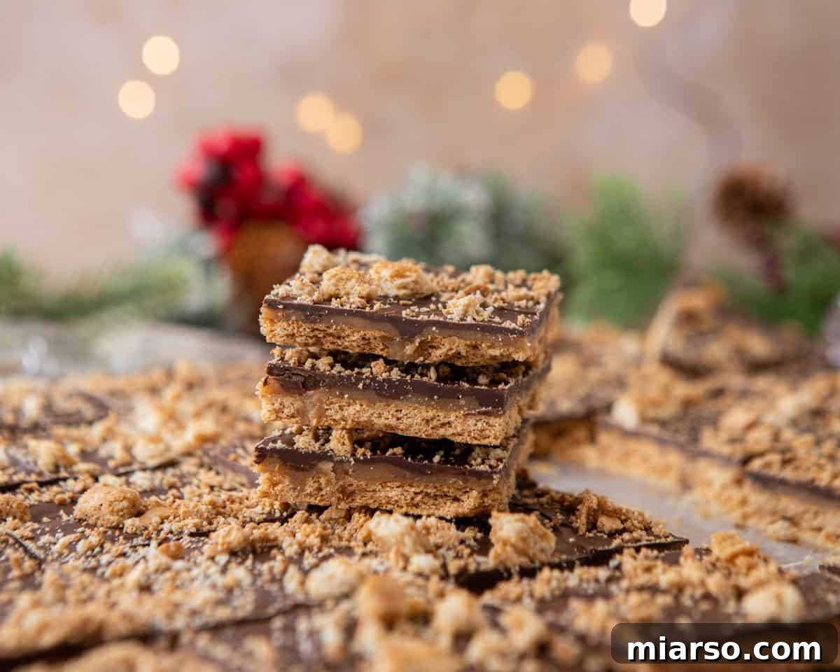 Graham cracker Christmas crack stacked in layers with chocolate and toffee