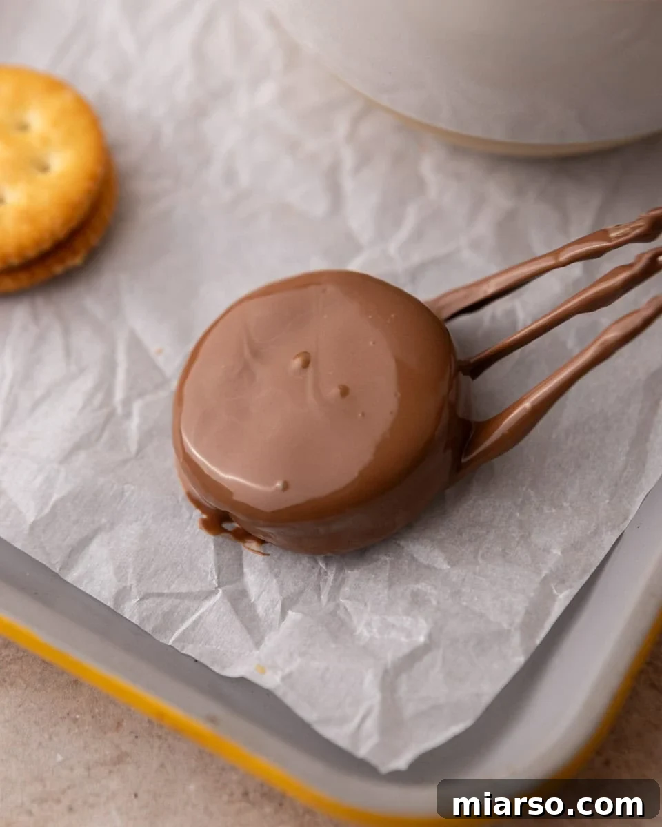 Chocolate coated Ritz cookie dripping excess chocolate