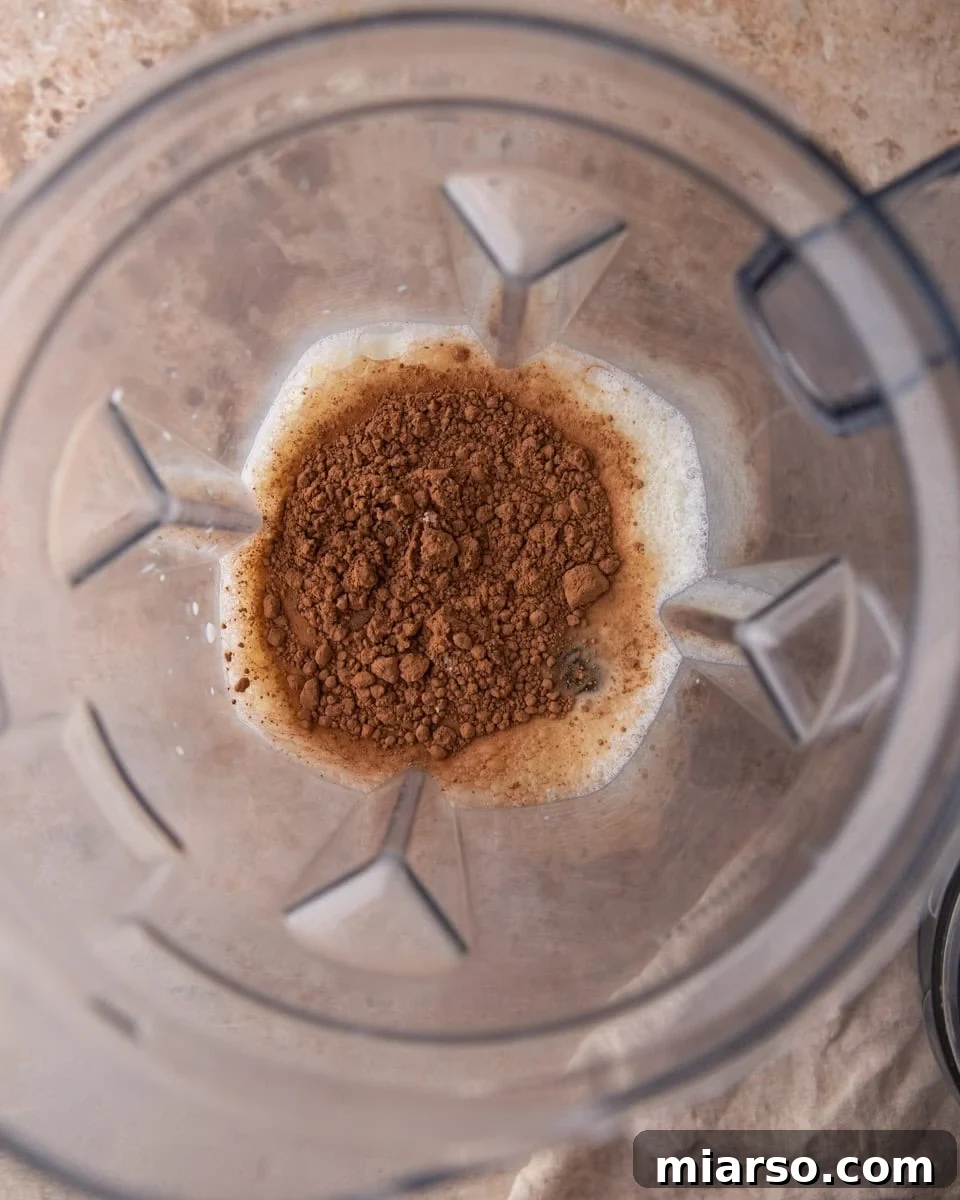 Cocoa powder and milk added to a blender