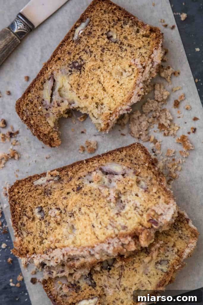Decadent pecan banana bread with a golden streusel topping, perfectly baked and ready to slice