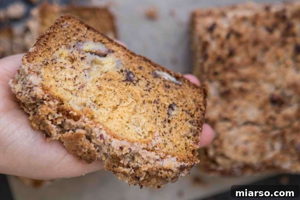Two slices of pecan banana bread with streusel, showcasing its moist texture and nut clusters