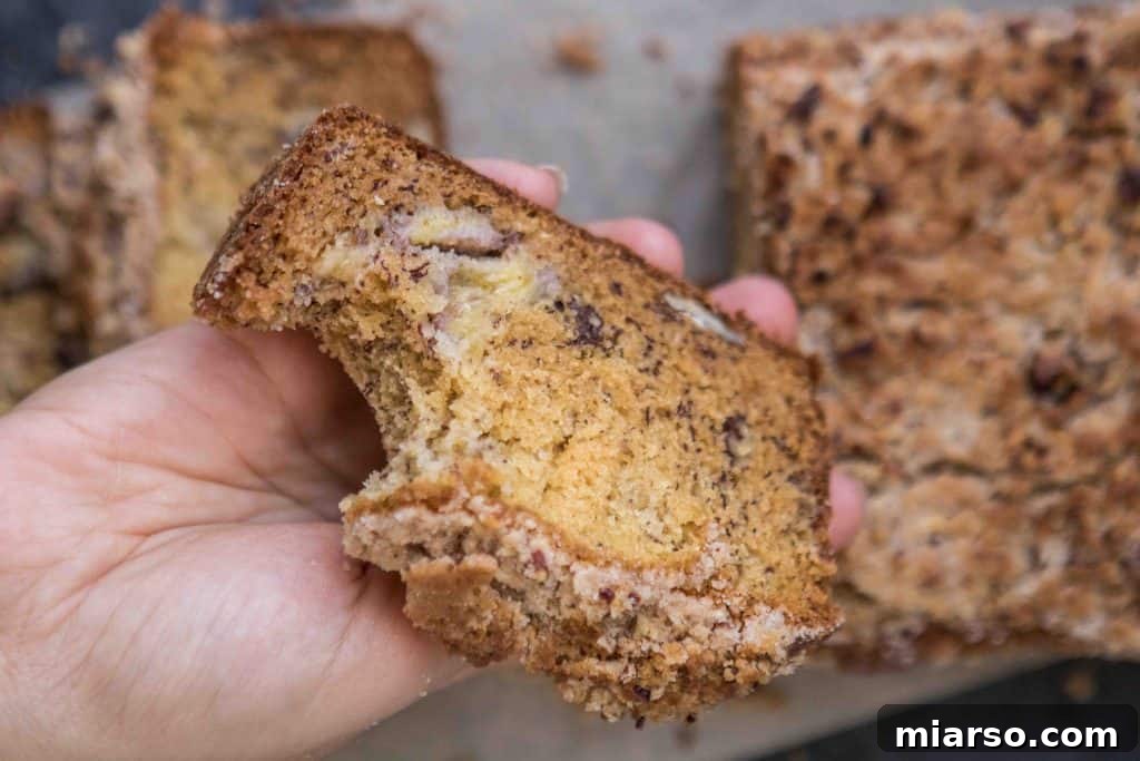 Close up on a single slice of homemade banana bread, highlighting its rich, golden-brown color