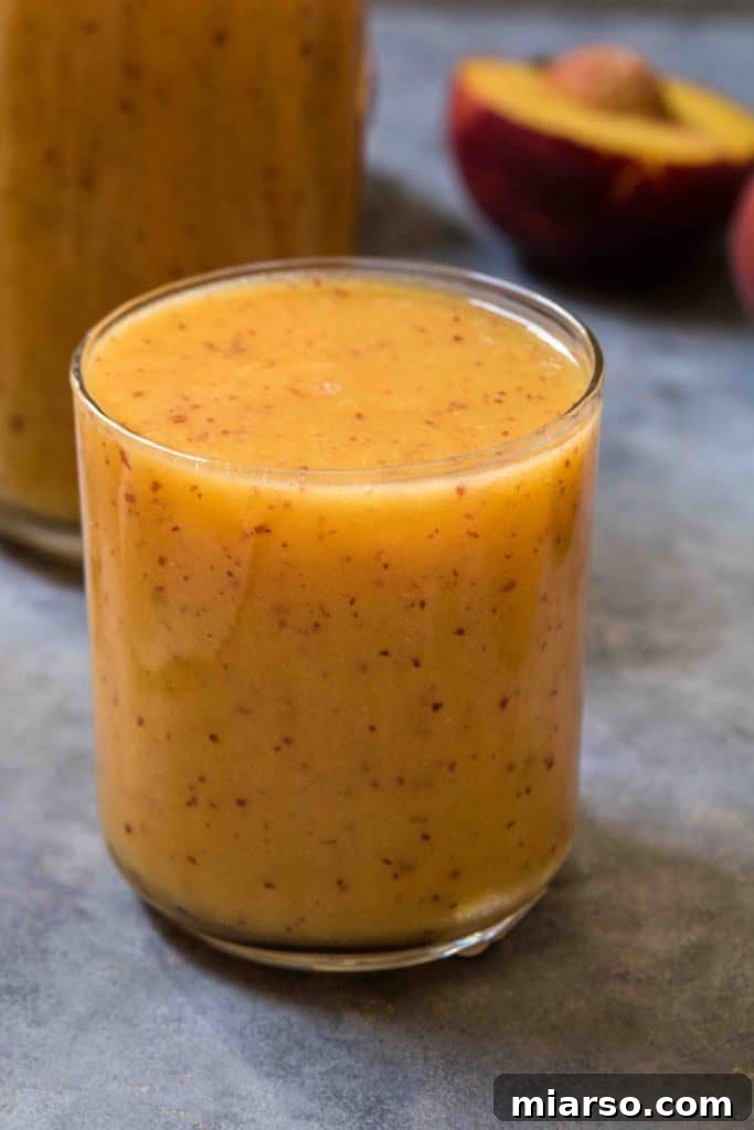 Citrus Peach CBD Serenity Smoothie 2 Vibrant peach smoothie in a glass jar, garnished with fresh peach slices and mint