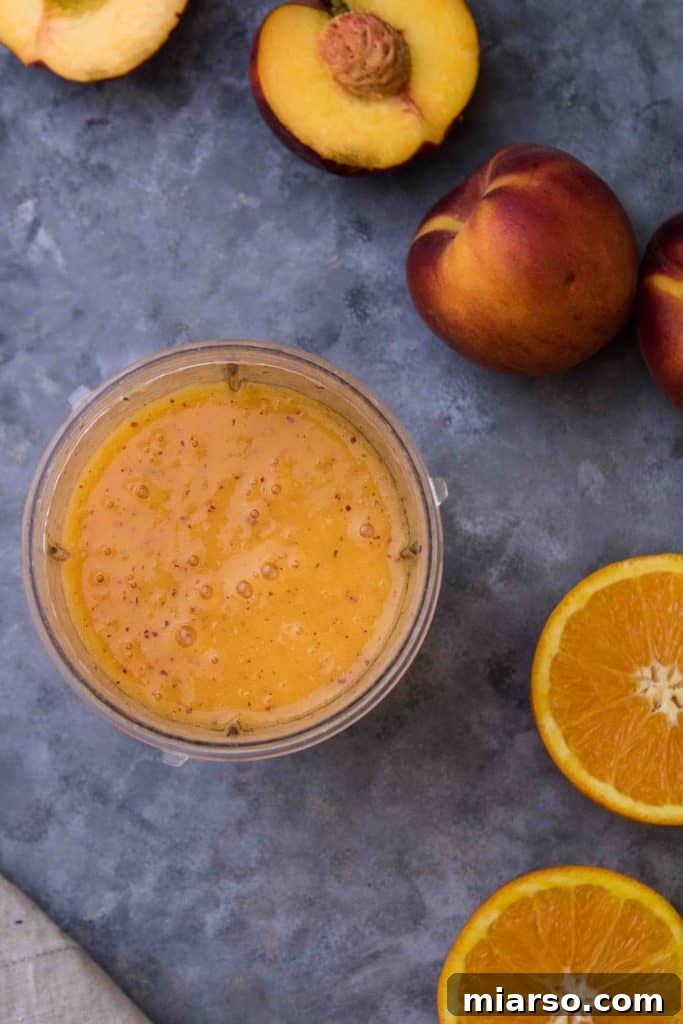 Citrus Peach CBD Serenity Smoothie 5 Two vibrant glasses of CBD oil infused healthy anti-inflammatory peach smoothie, garnished with fresh fruit