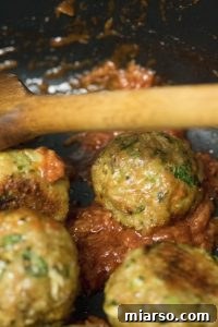 Indian chicken meatballs being coated in glaze