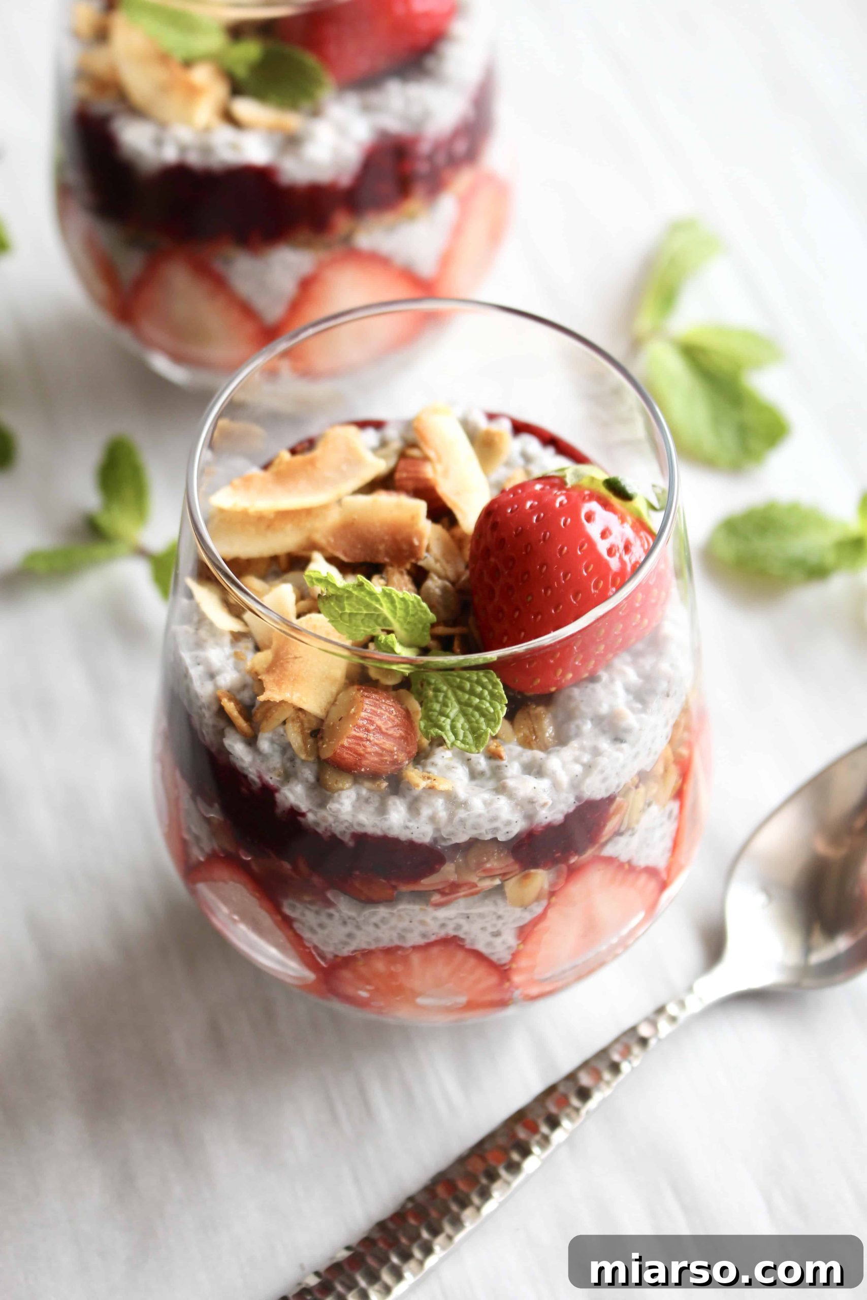 Close-up of a Berry Chia Seed Parfait with vibrant layers of berries, shredded coconut, and golden granola, ready to be enjoyed