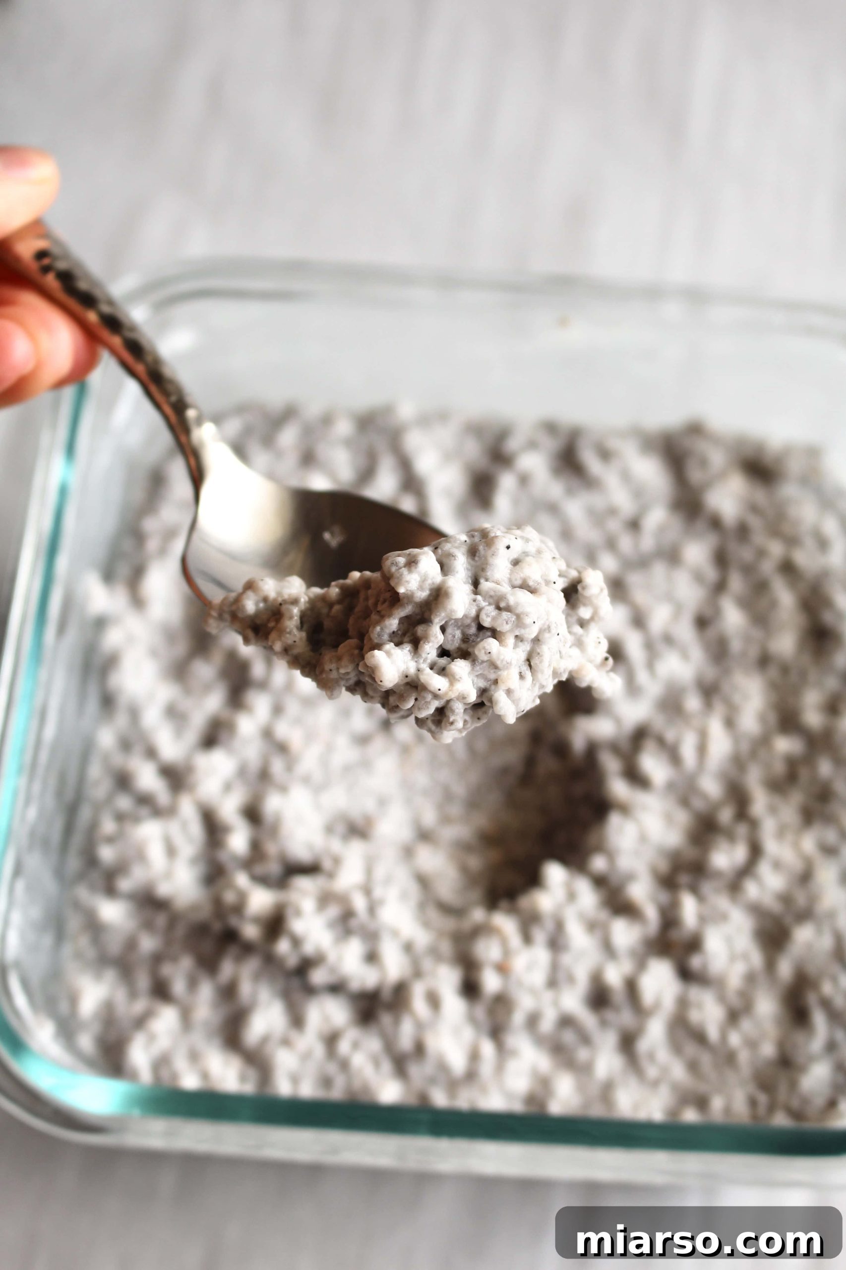 Chia seeds soaking in non-dairy milk in a glass bowl, a crucial first step for making creamy chia pudding