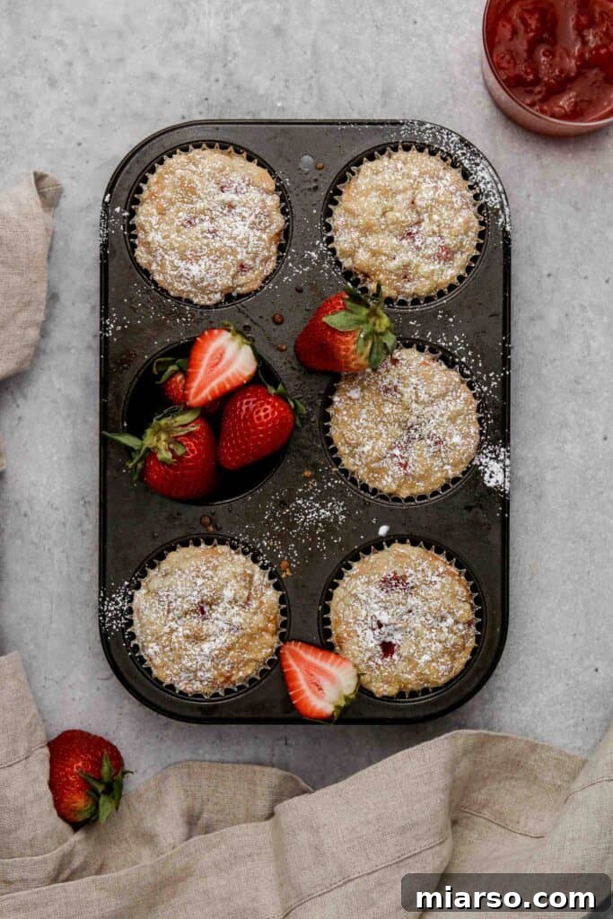 Freshly baked strawberry jam filled muffins coming out of the oven