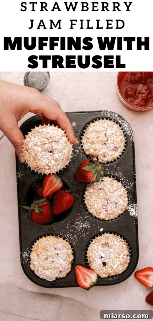 Close-up of a homemade strawberry jam filled muffin with streusel topping