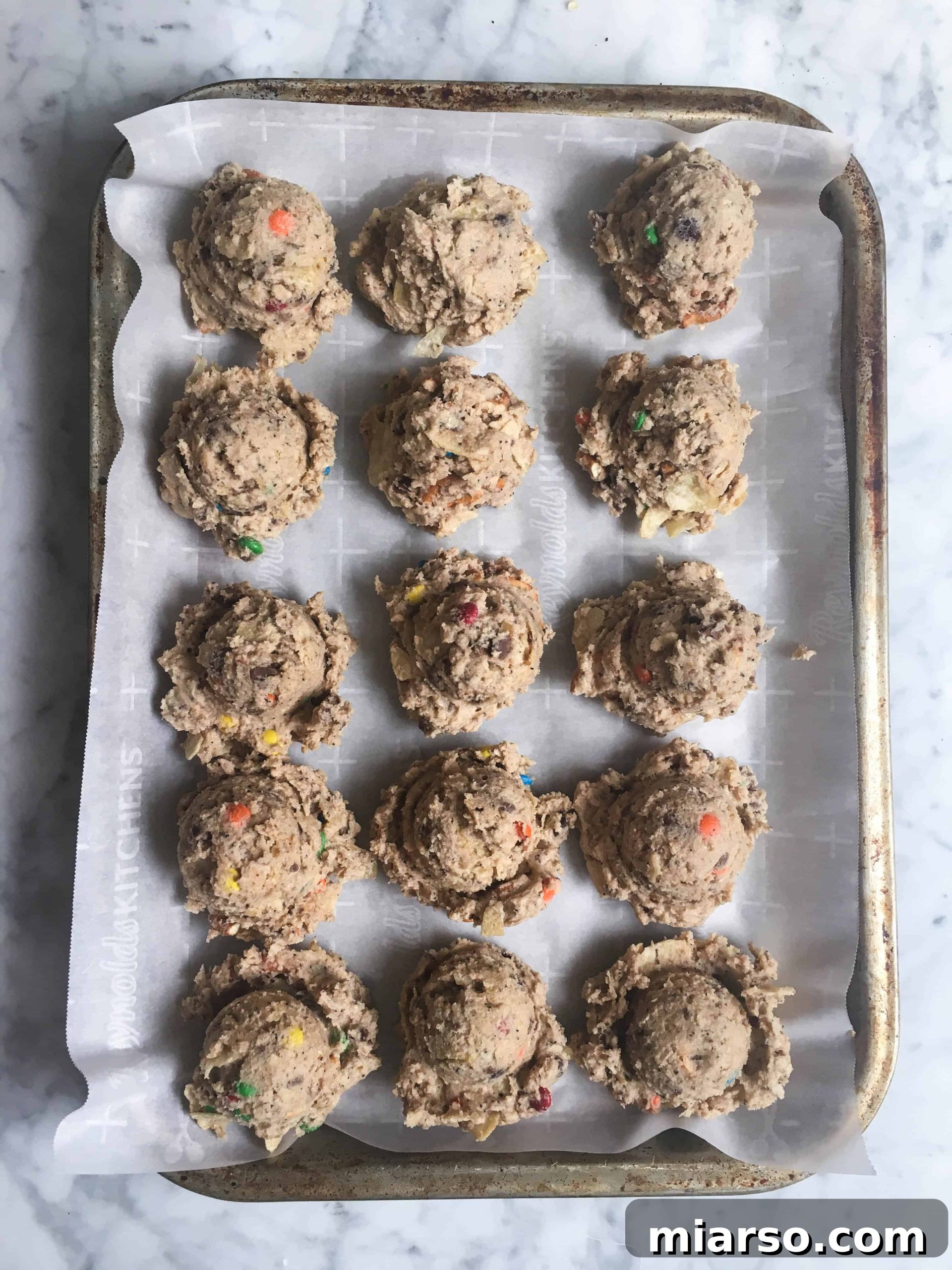 Portioning out Momofuku and Milk Bar compost cookie dough onto a baking sheet, ready for chilling and baking.
