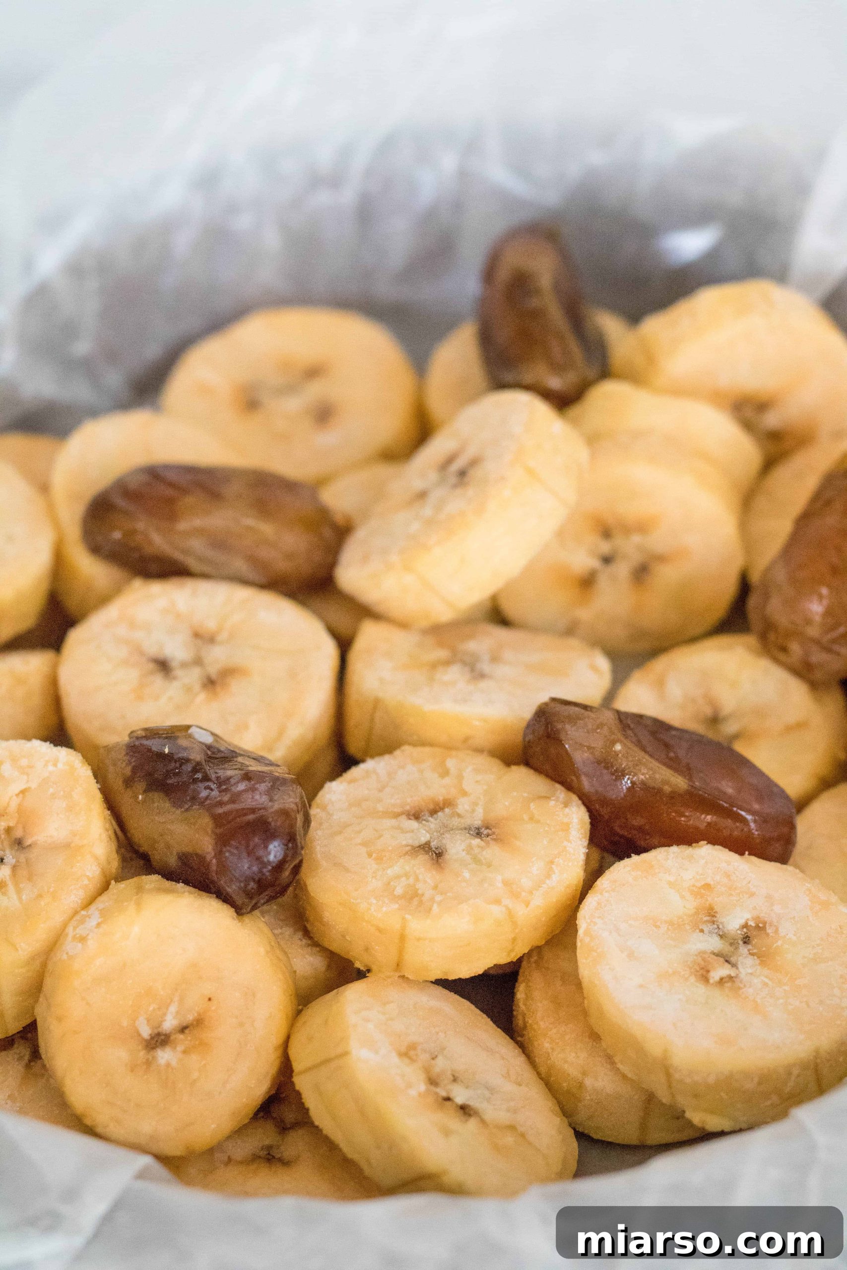 Creamy Vegan Biscoff Date Plantain Nice Cream 4 Sliced ripe plantains on a baking sheet, ready for freezing