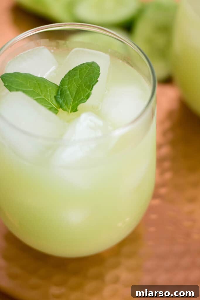 Grape and cucumber refresher served in a rustic glass jar, surrounded by fresh ingredients.
