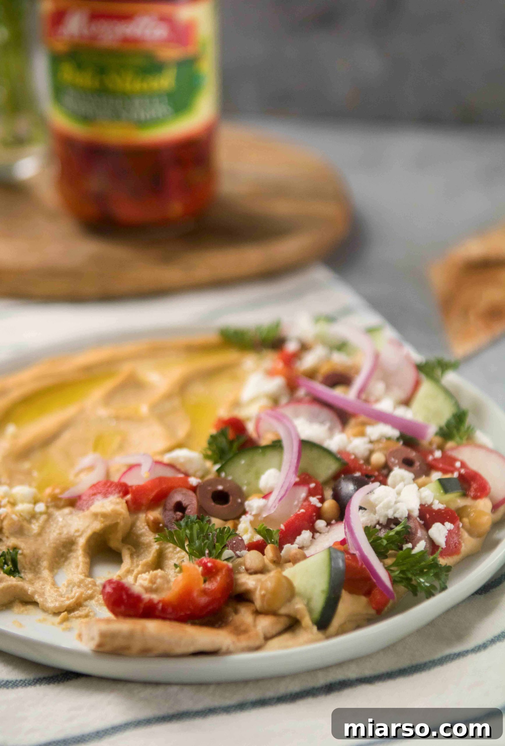 Effortless Mediterranean Hummus Platter 3 Close-up of Mediterranean loaded hummus with fresh vegetables and herbs