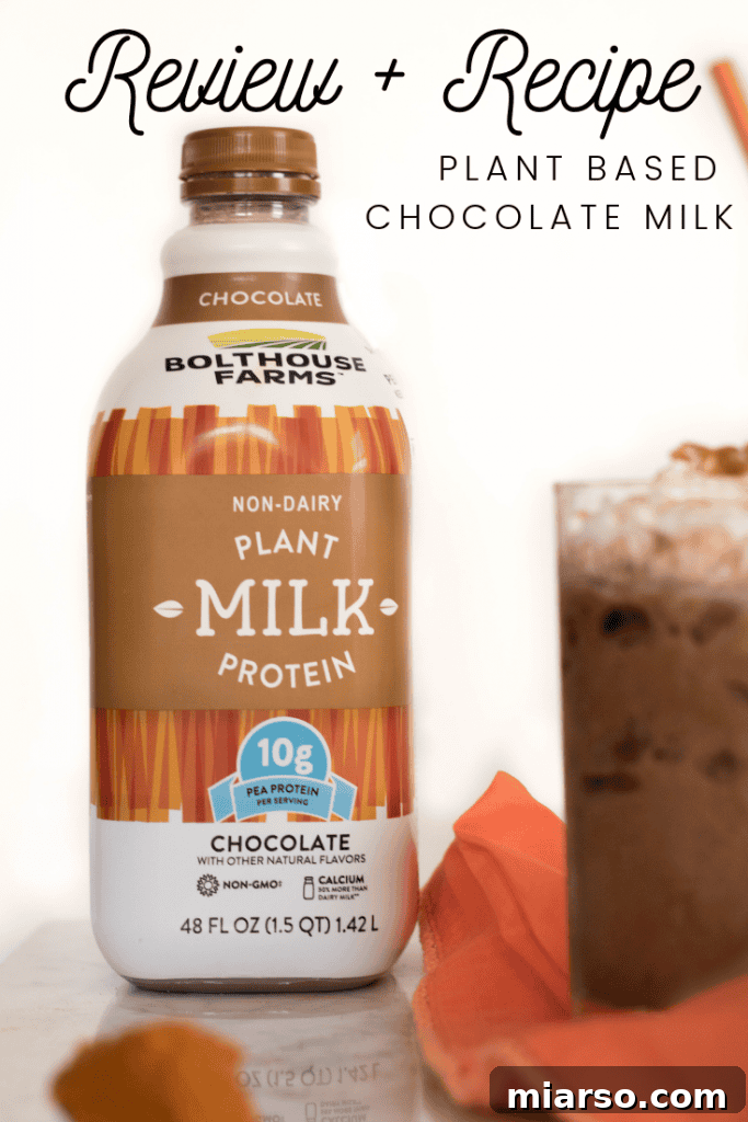 The Ultimate Vegan Iced Pumpkin Spice Hot Chocolate 9 A hand holding a glass of Iced Vegan Pumpkin Spice Hot Chocolate outdoors