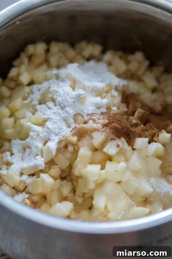 Diced apples and spices mixing in a saucepan for homemade donut filling