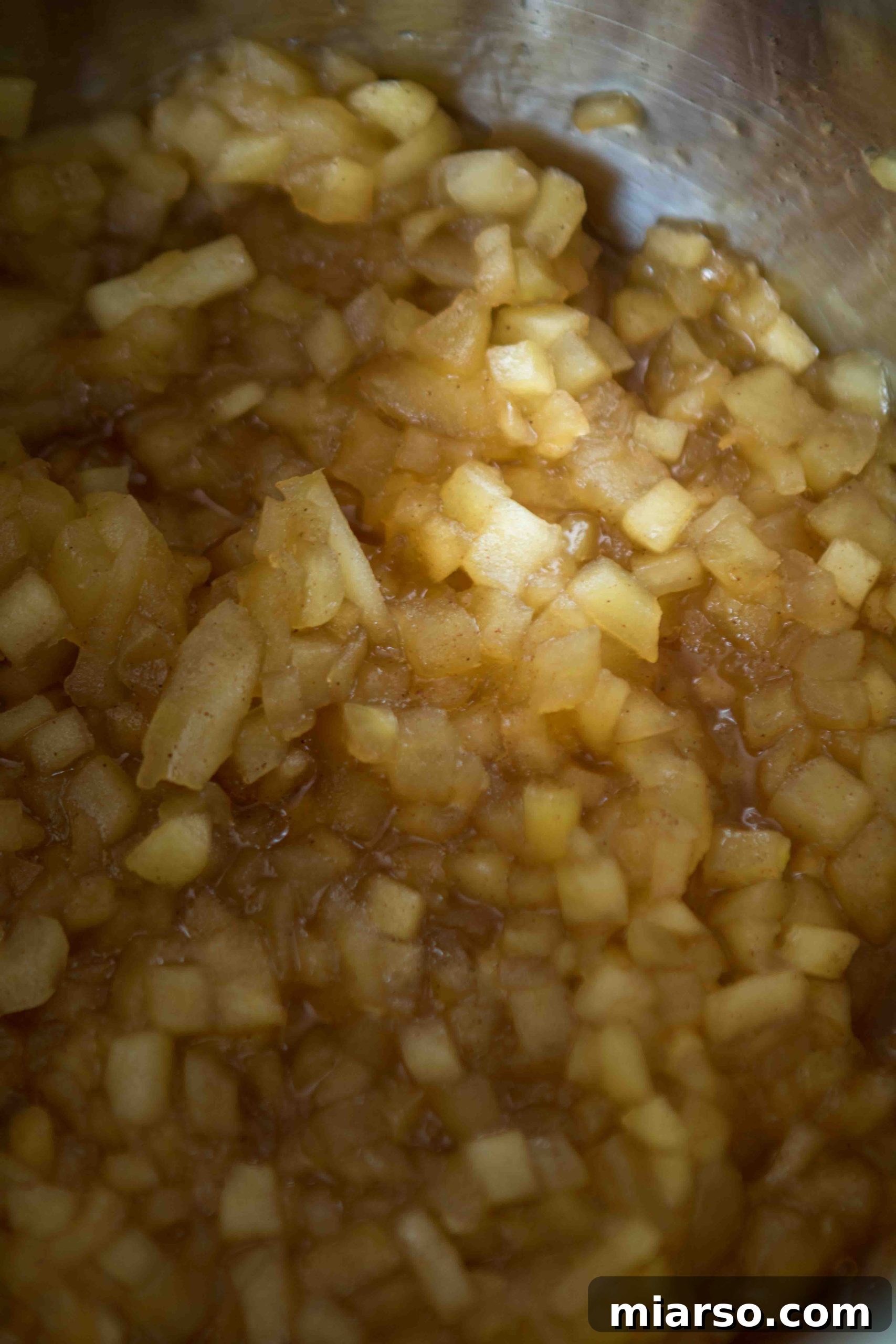 Apple filling simmering gently in a saucepan, developing rich flavors and texture