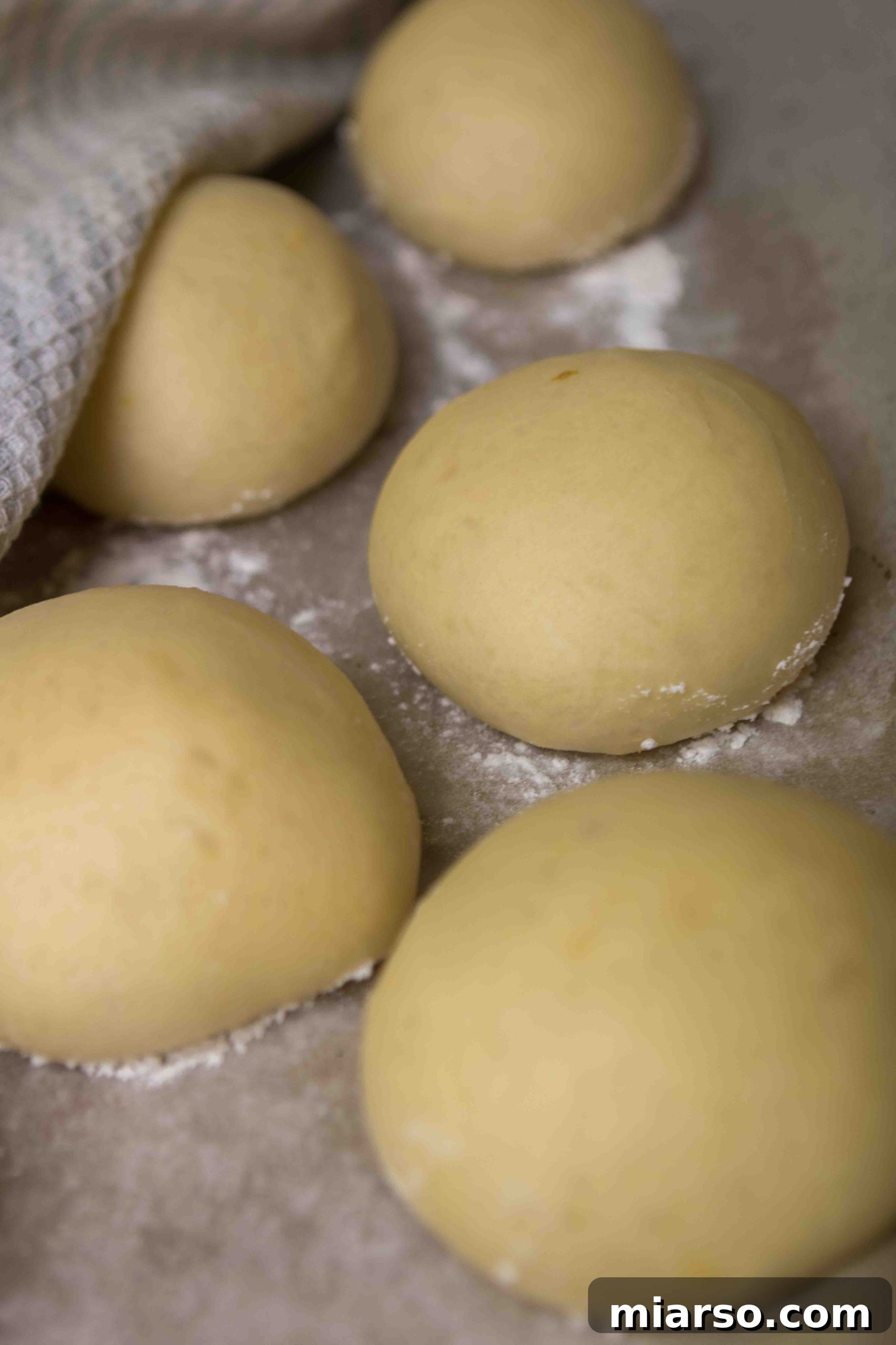 Donut dough balls after rising, showing significant increase in size