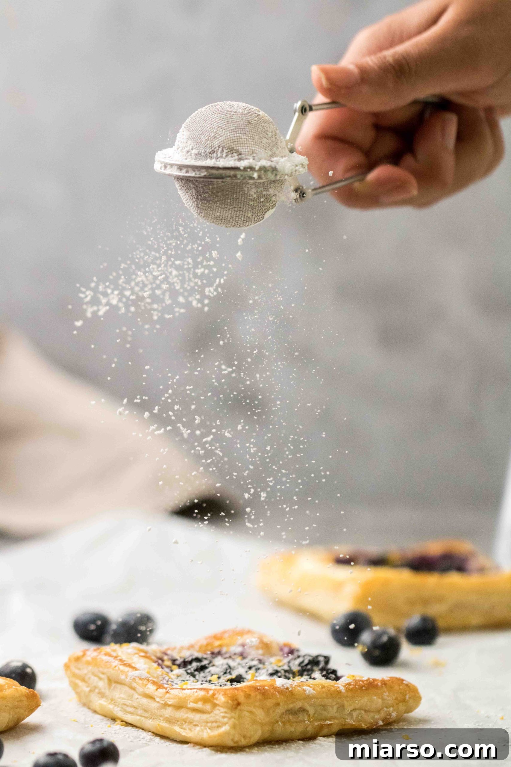 Flaky Blueberry Cheese Danish Made Easy 2 Delicious blueberry cheese danish with puff pastry, dusted with powdered sugar, ready for breakfast or brunch.