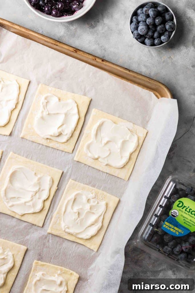 Flaky Blueberry Cheese Danish Made Easy 7 Applying cream cheese filling to puff pastry squares.