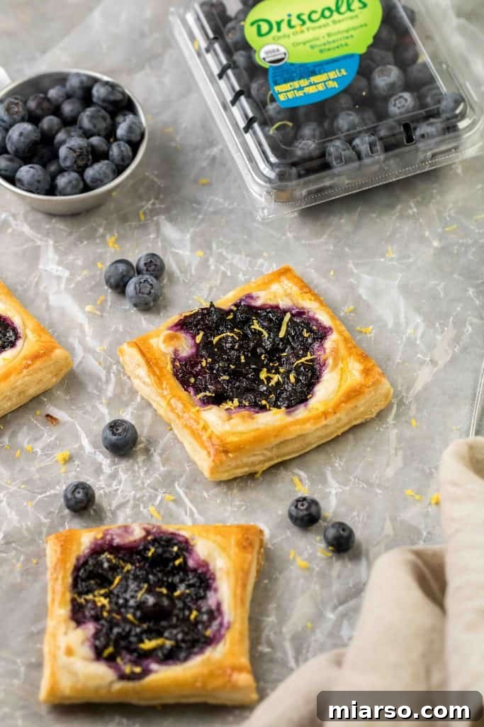 Flaky Blueberry Cheese Danish Made Easy 9 Finished blueberry cheese danishes dusted with powdered sugar.