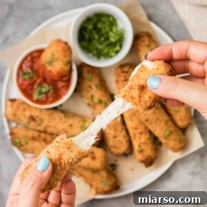 Air fryer cheese stick with cheese oozing out, golden and crispy
