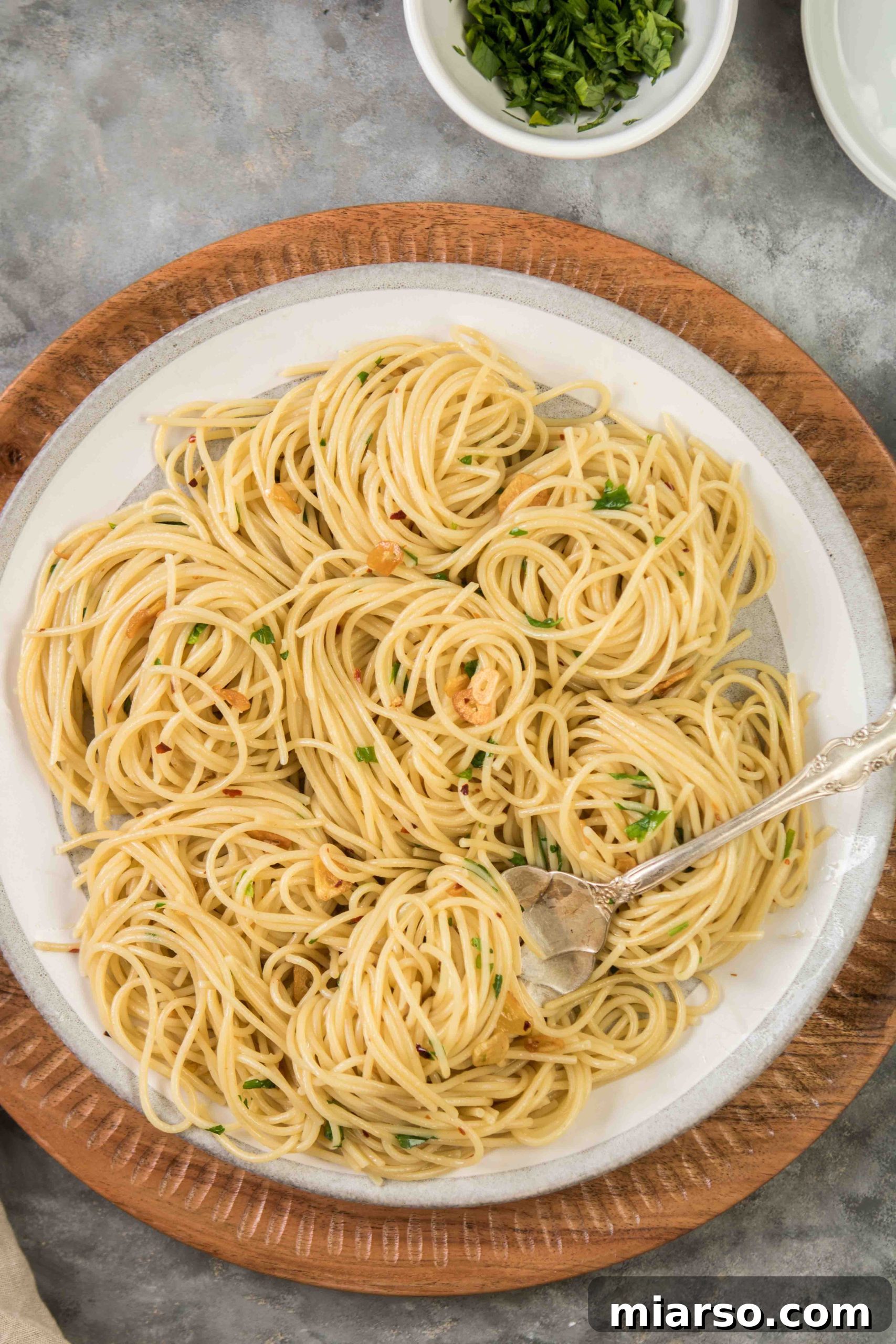 Aromatic Garlic and Olive Oil Spaghetti 2 Quick and easy spaghetti dinner with olive oil and garlic on a plate, garnished with fresh parsley.