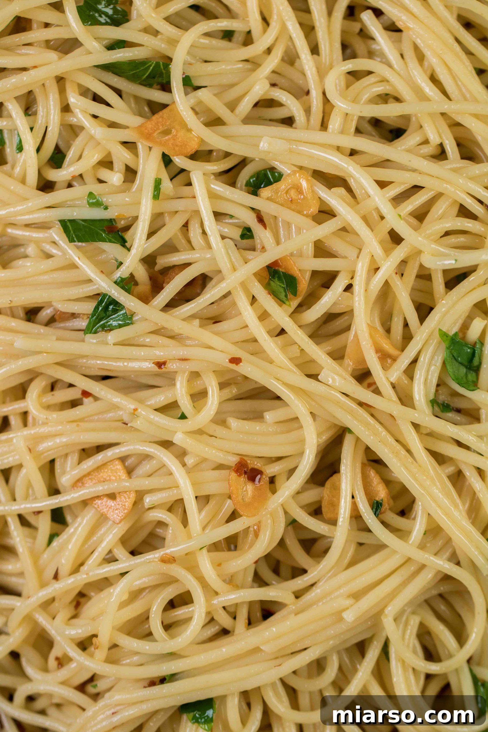 Aromatic Garlic and Olive Oil Spaghetti 3 Close-up shot of perfectly caramelized garlic with spaghetti and a sprinkle of parmesan cheese, showcasing the rich textures.