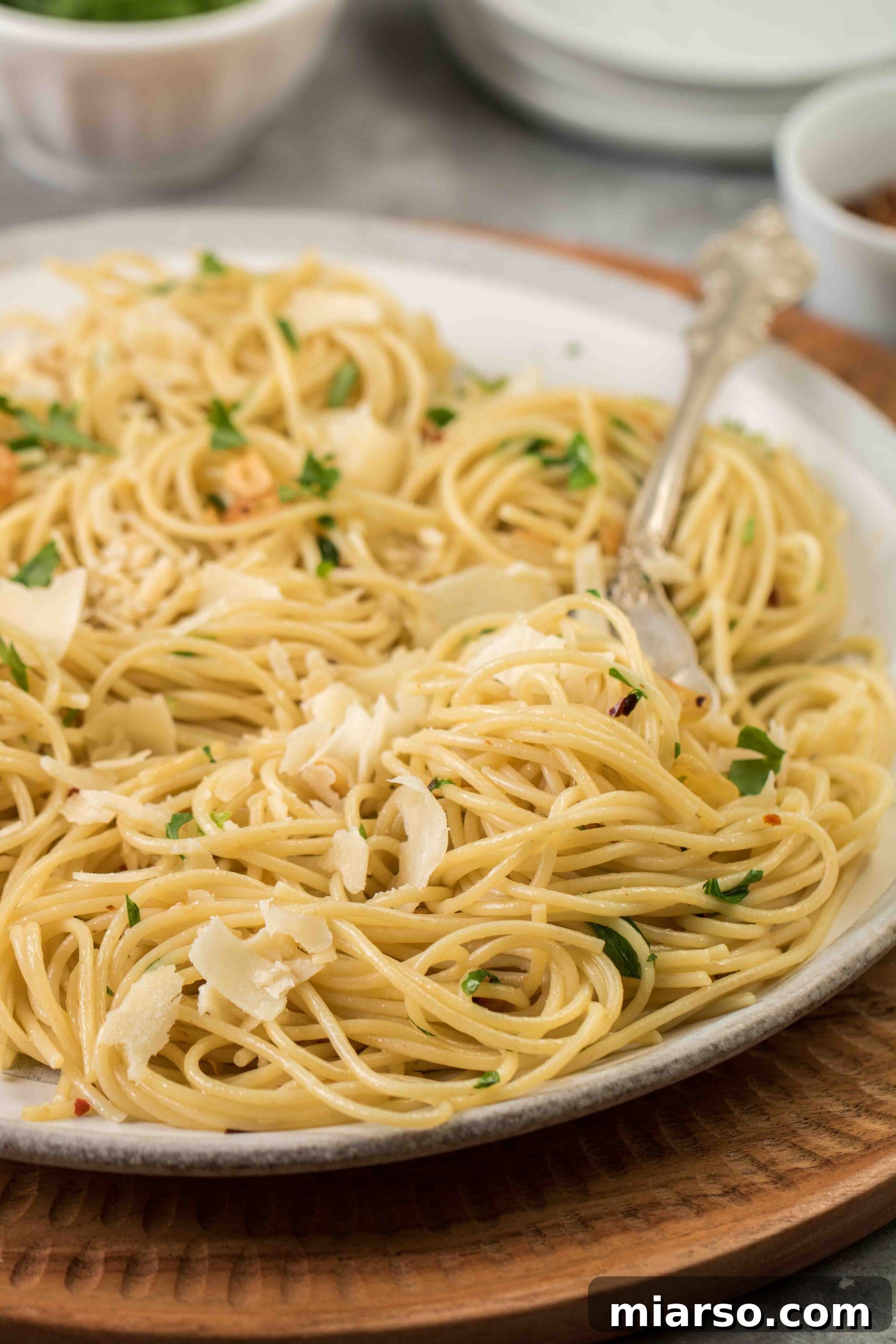 Aromatic Garlic and Olive Oil Spaghetti 5 A serving of spaghetti aglio e olio in a bowl, with a serving utensil, perfectly ready to be enjoyed.