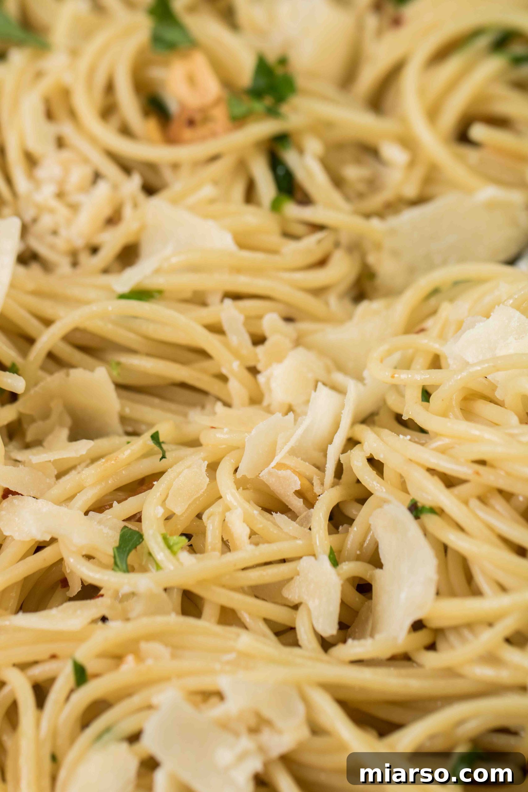 Aromatic Garlic and Olive Oil Spaghetti 6 A bowl of spaghetti with garlic and parmesan cheese, showcasing a beautifully plated and appetizing meal.