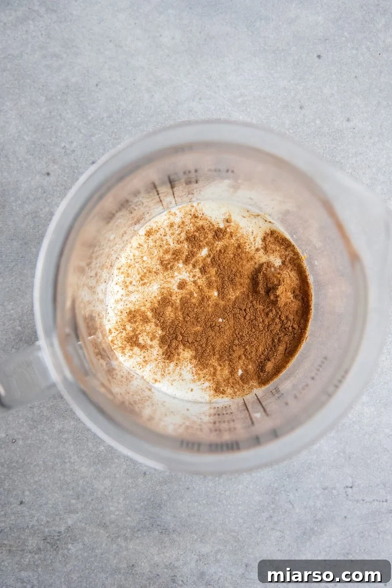 Fall's Ultimate Starbucks Pumpkin Cream Cold Brew 5 A close-up of pumpkin cold foam being poured into a glass of cold brew.