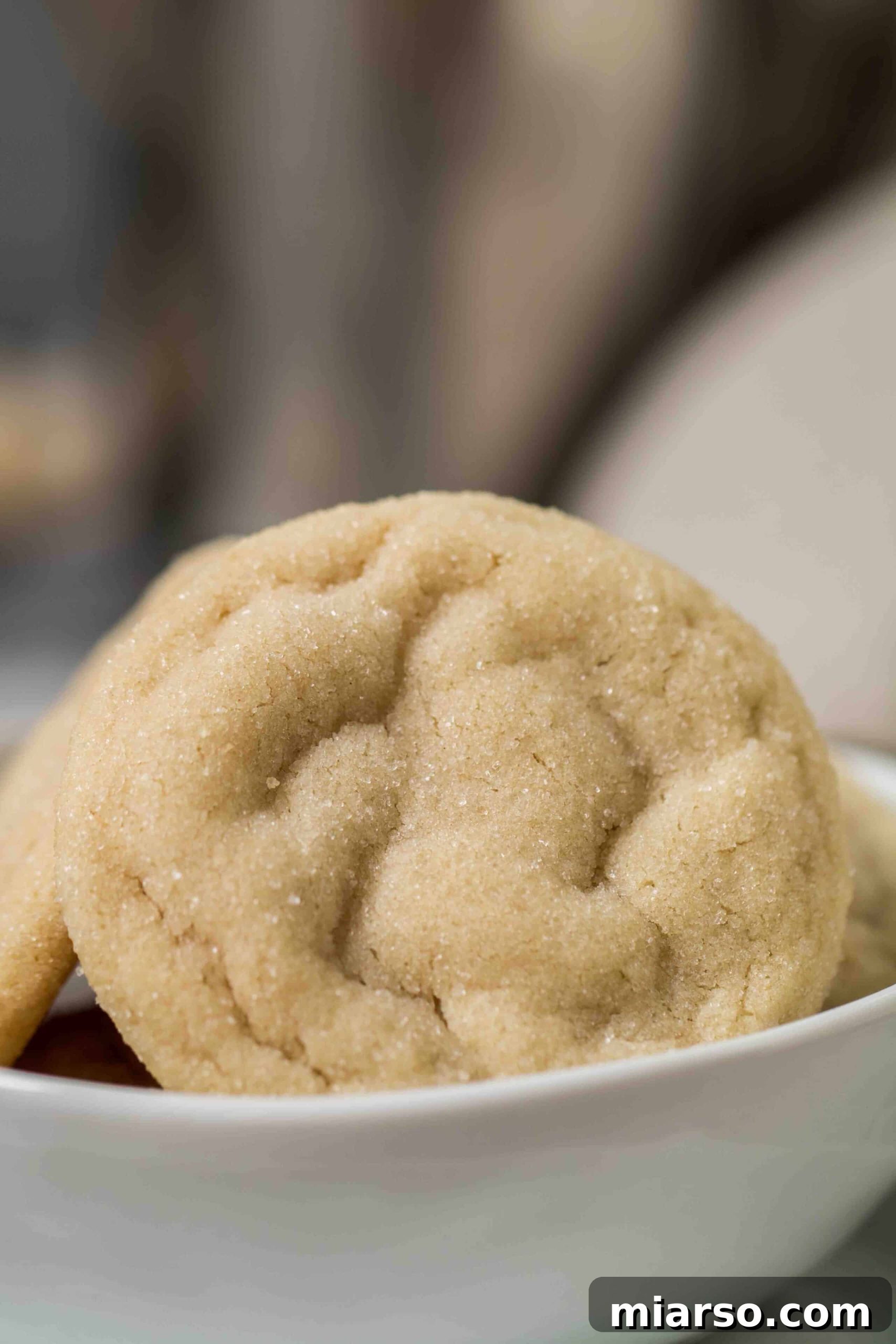 Soft sugar cookies perfectly arranged in a rustic bowl, showcasing their golden edges and delicate cracks.
