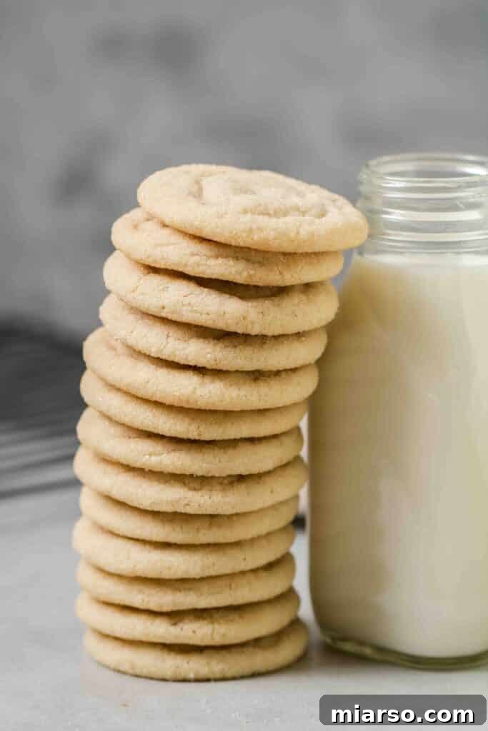 A tall stack of the softest, golden-brown sugar cookies, highlighting their perfectly rounded shape and inviting texture.