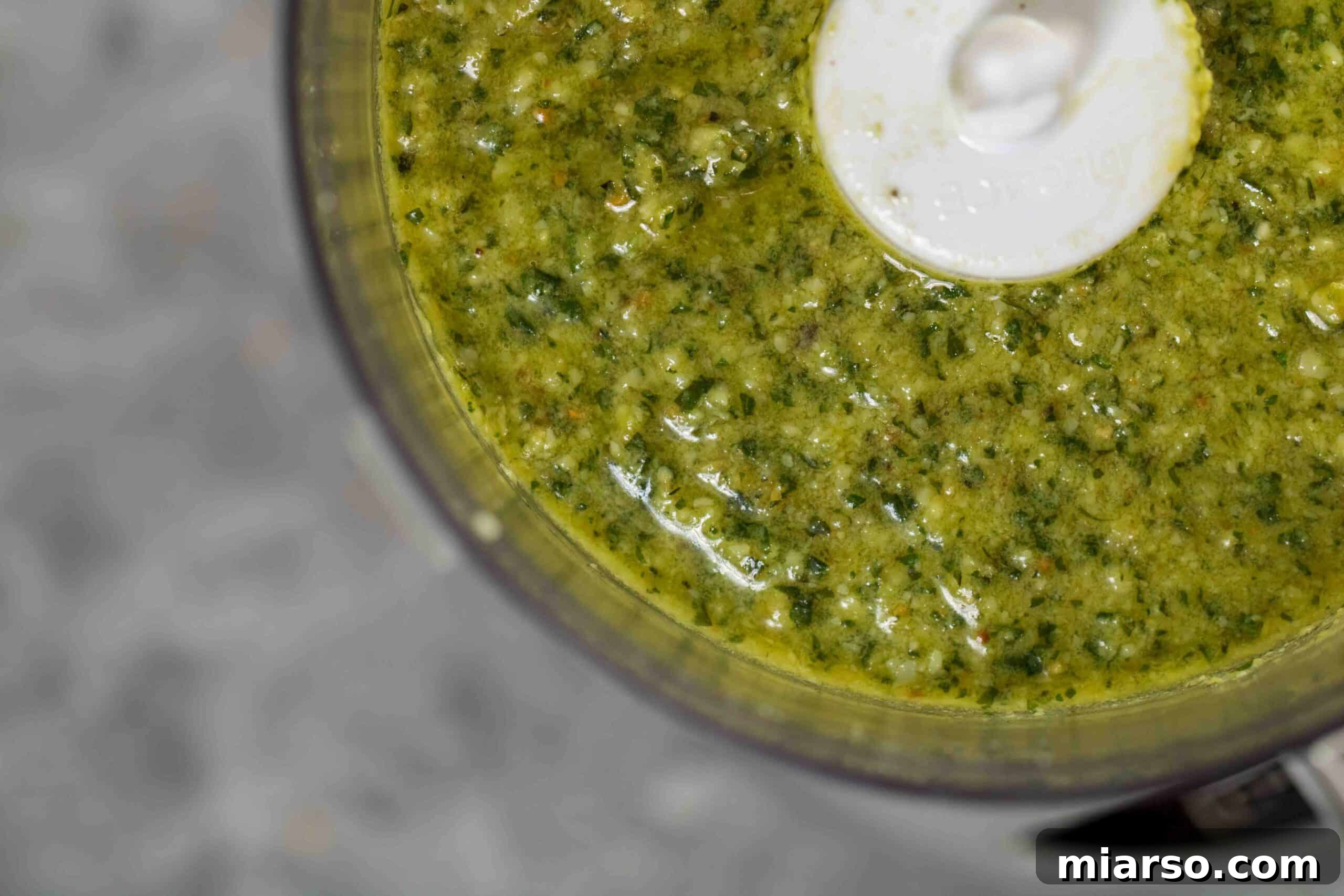 Effortless Homemade Pesto Perfection 3 Overhead close up shot of texture of green pesto recipe, showcasing its vibrant color and rich consistency.