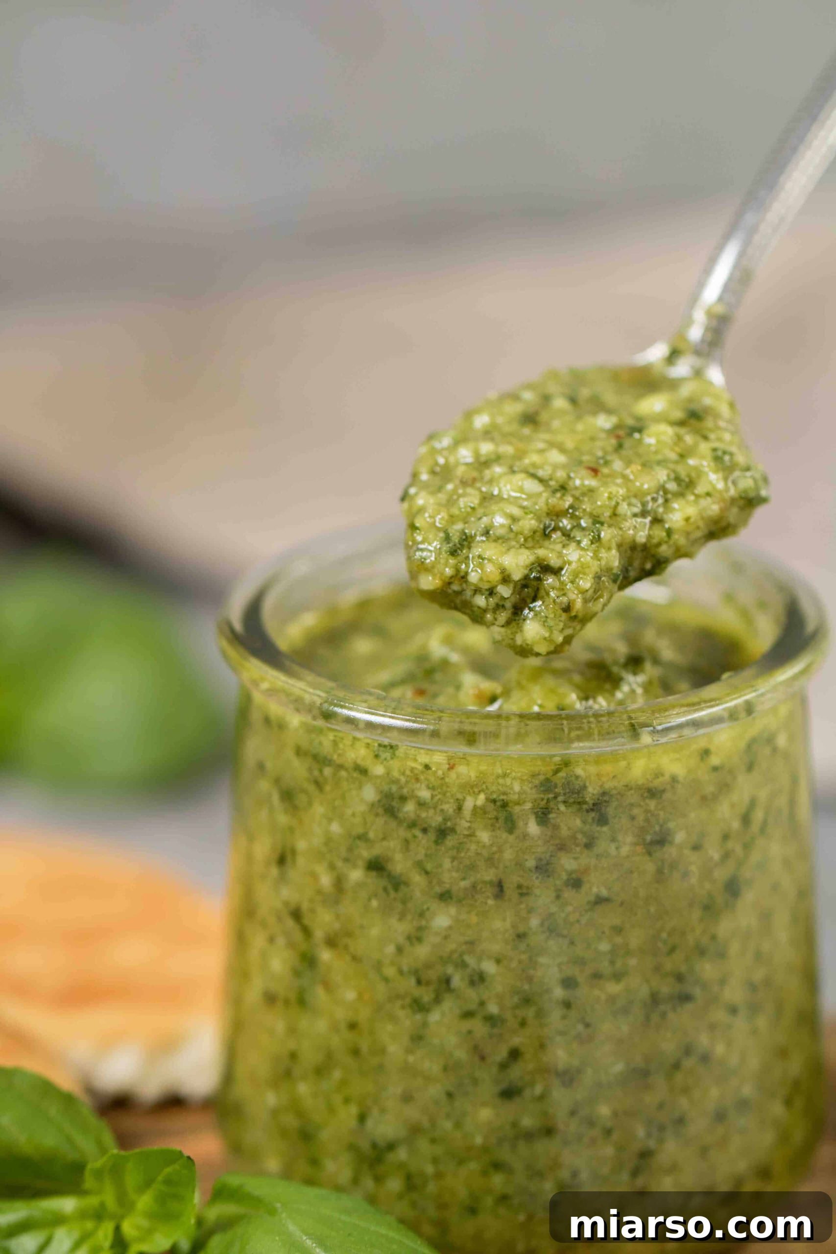 Effortless Homemade Pesto Perfection 9 Spoon filled with creamy pesto sauce, showing its rich texture.