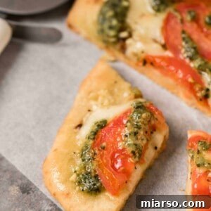 Slice of Margherita pesto pizza ready to be served