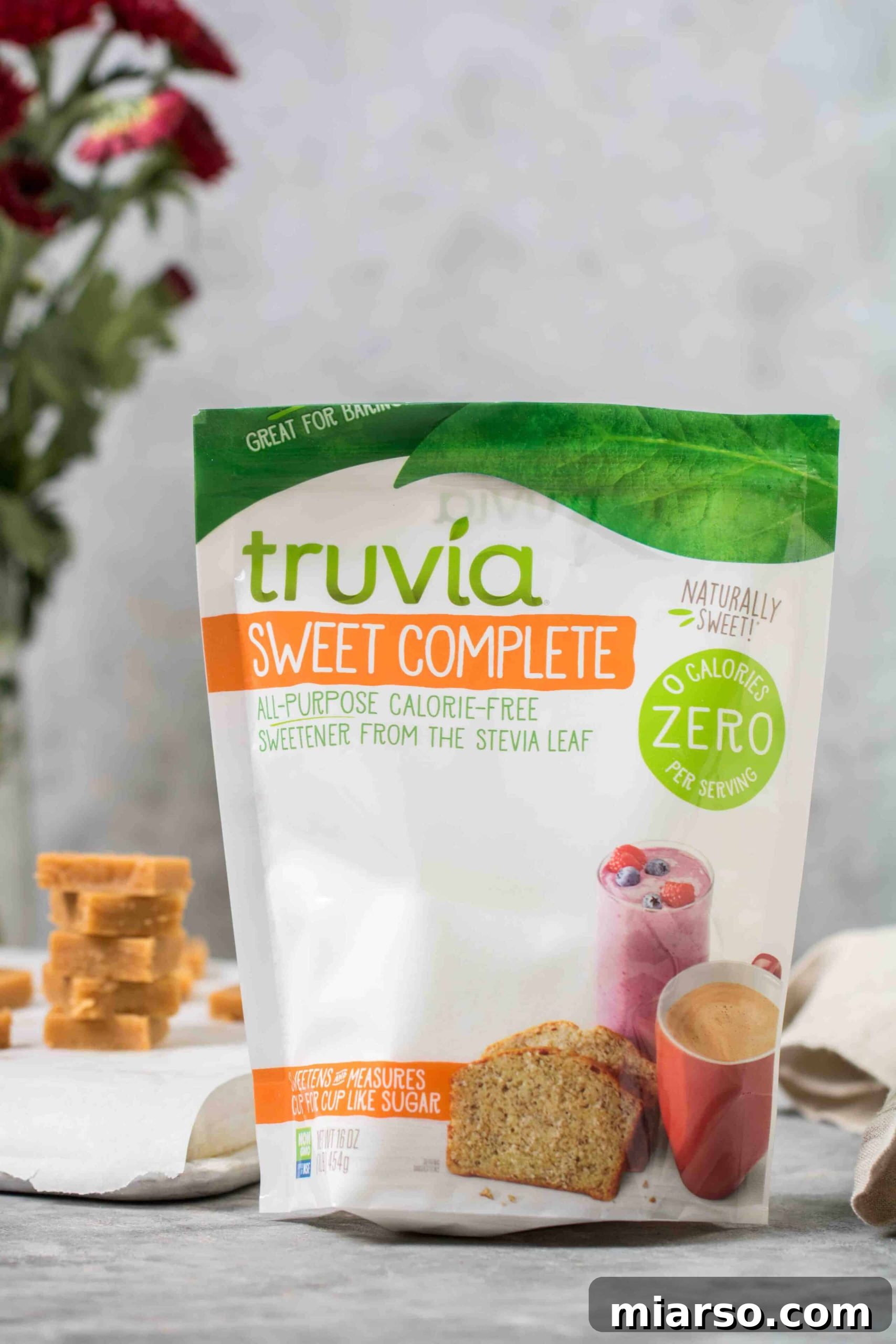 Close up of Truvia Sweet Complete sweetener with creamy keto peanut butter fudge squares in the background, showcasing the key ingredient.