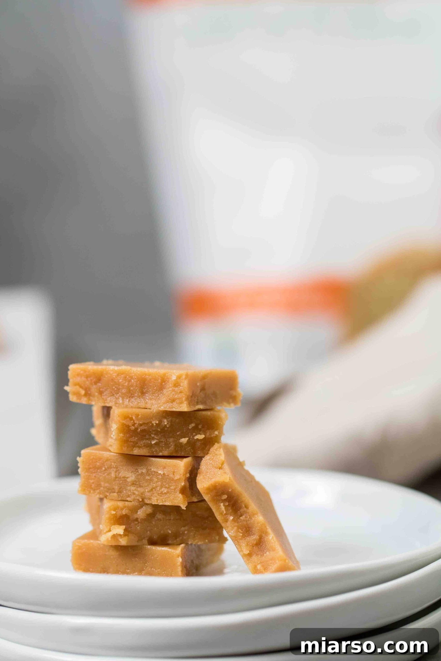 A stack of perfectly cut, melt-in-your-mouth low carb peanut butter fudge squares, ready to be enjoyed as a keto-friendly dessert.