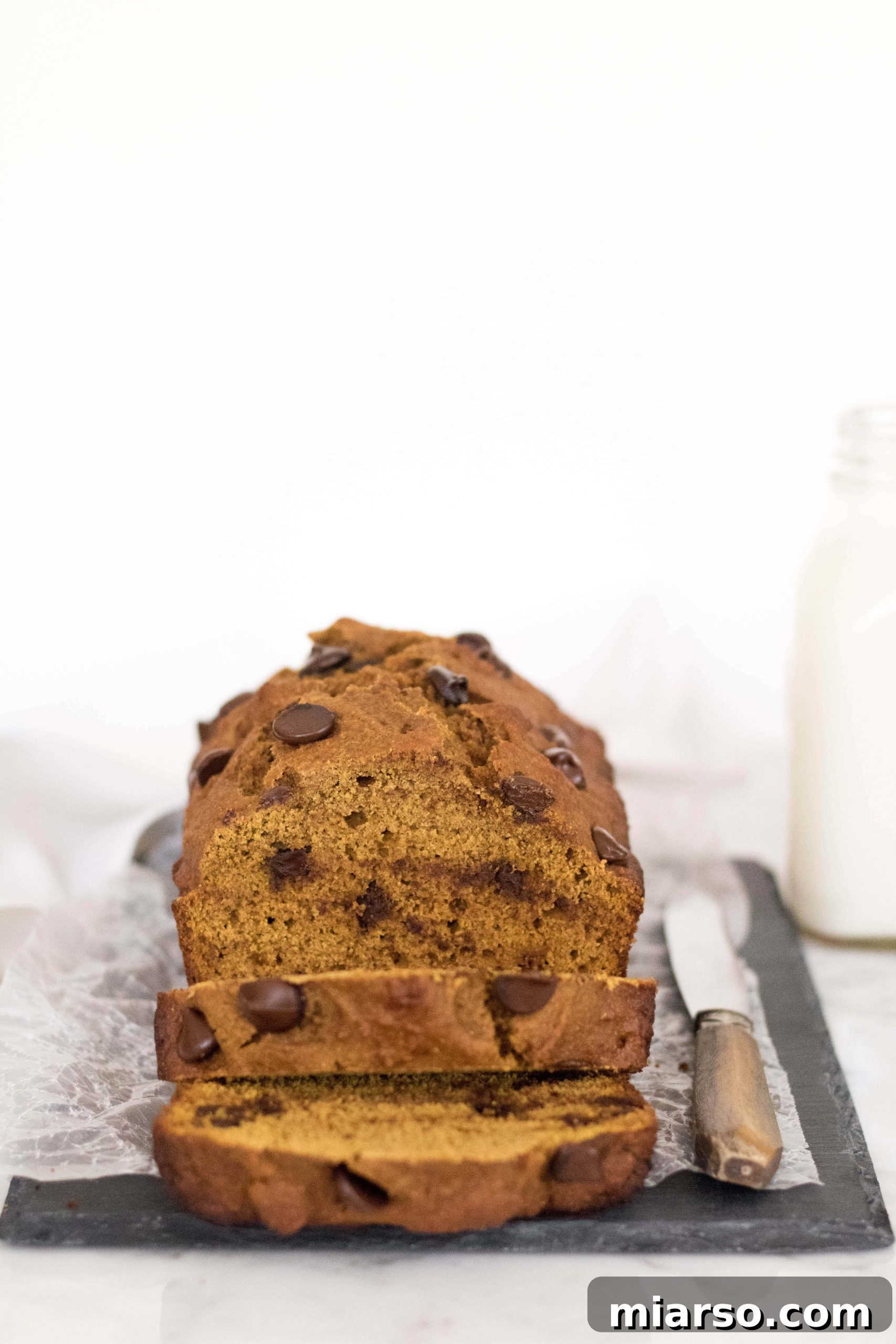 Close-up of healthy pumpkin bread revealing its moist texture and golden hue, with chocolate chips peeking out.