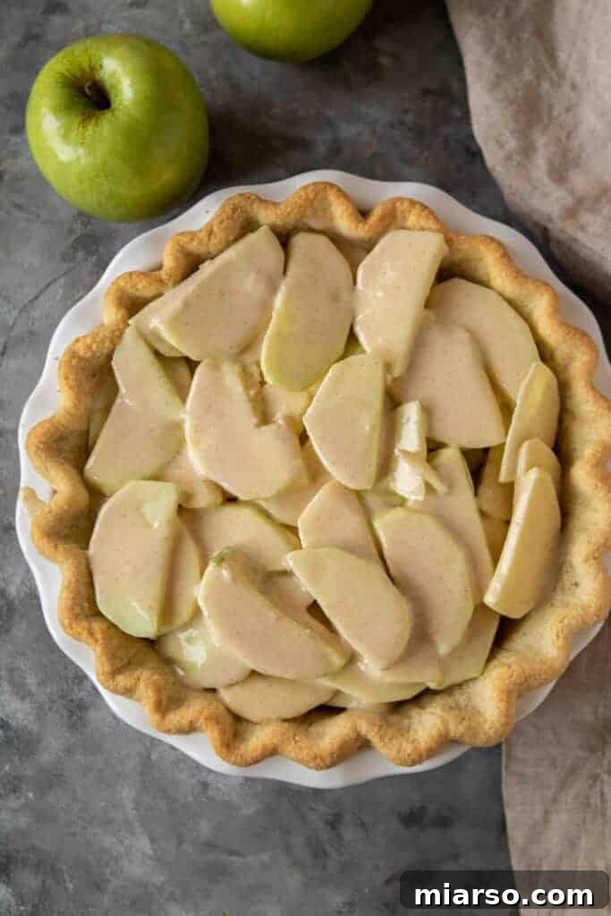Partially baked pie with apple filling, before the streusel topping is added.